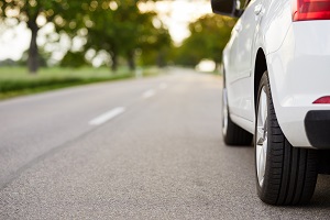 white car driving down the road