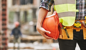 up close of construction worker holding orange hard hat